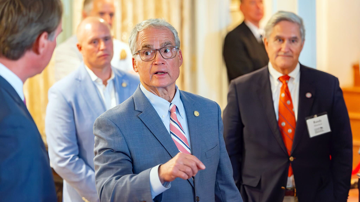 Geary Higgins of Virginia stands with people at political event