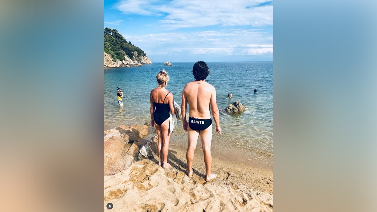 Goldie Hawn and Oliver Hudson take pictures behind their swimsuits.