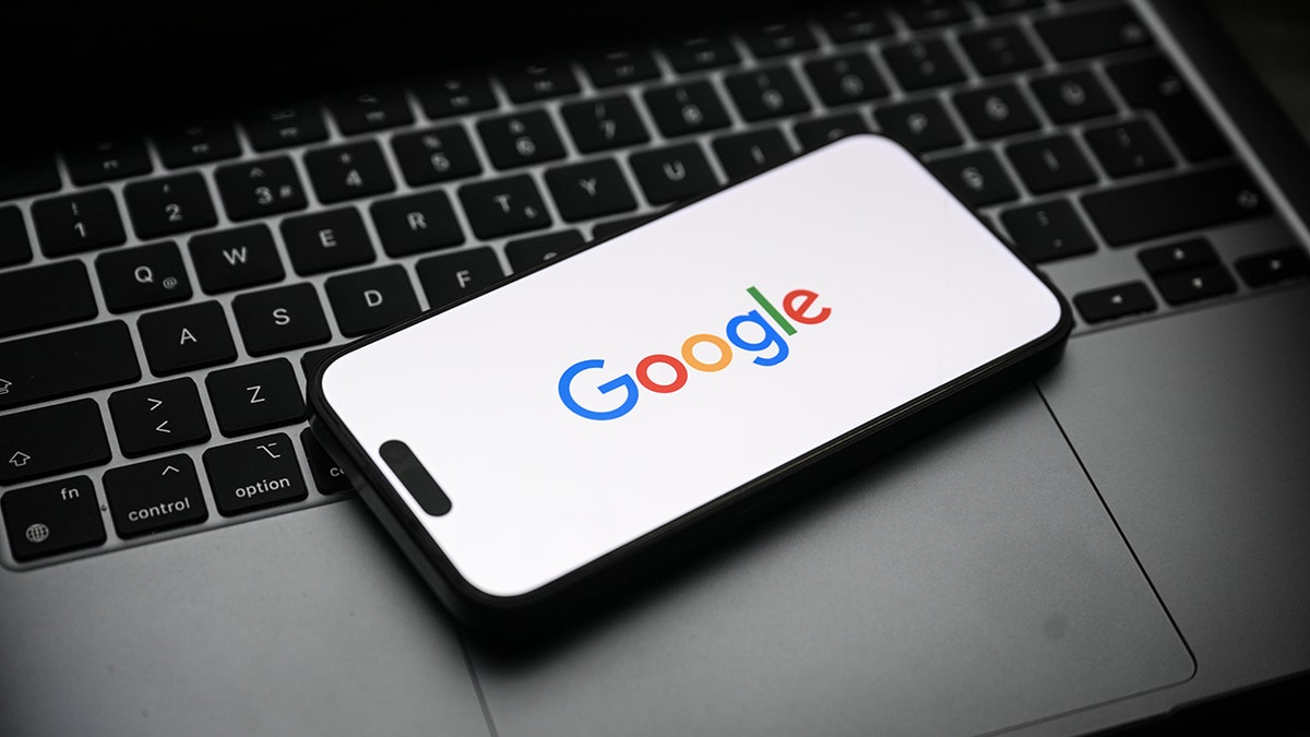 Smartfon spoczywa na laptopie.