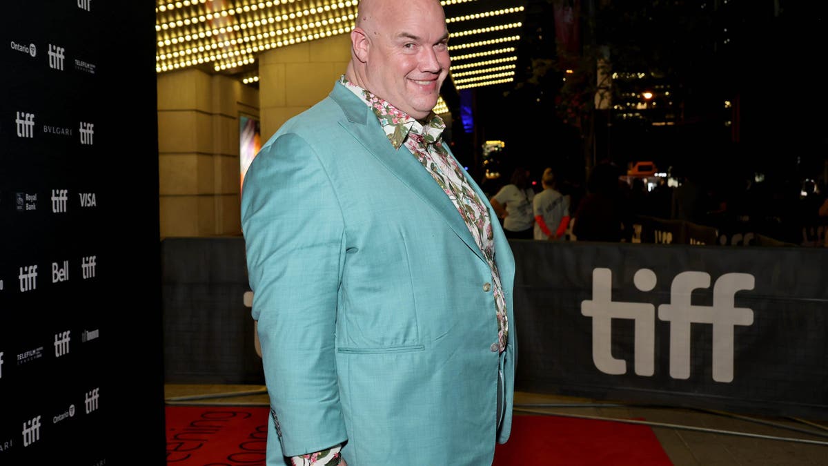Guy Branum smiles while standing on TIFF red carpet.