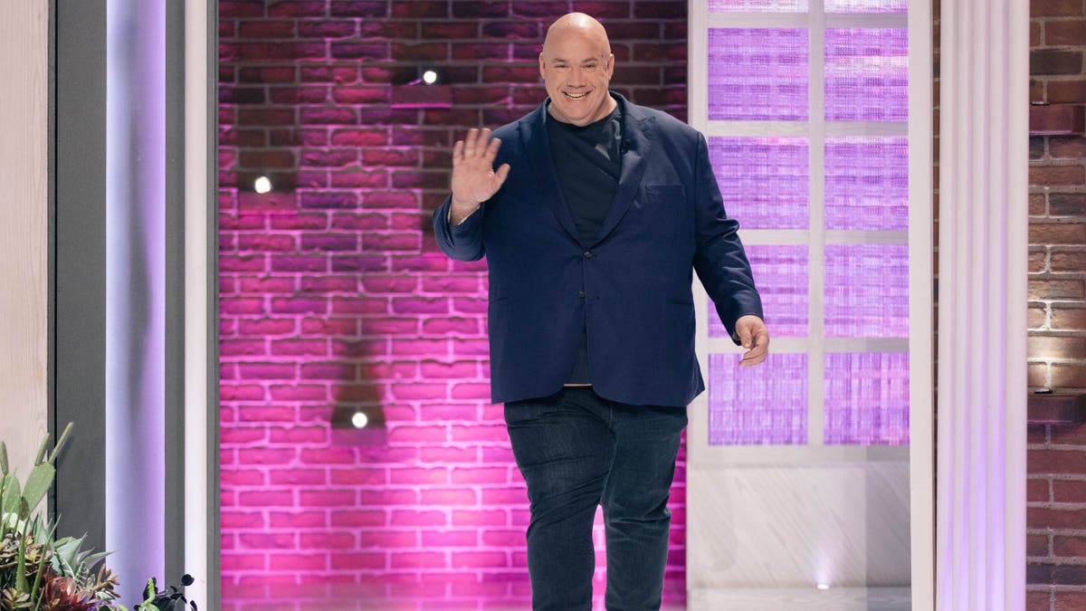 Guy Branum waves while appearing on The Kelly Clarkson Show. 