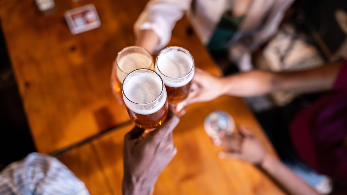 Coworkers clinking beers together