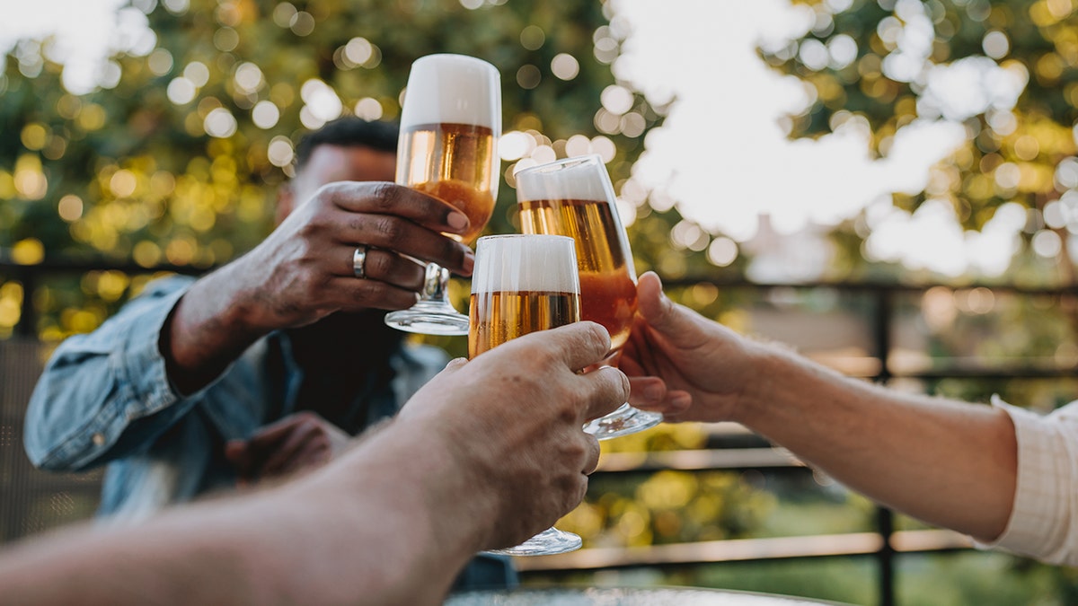 Men clicking beers together outside