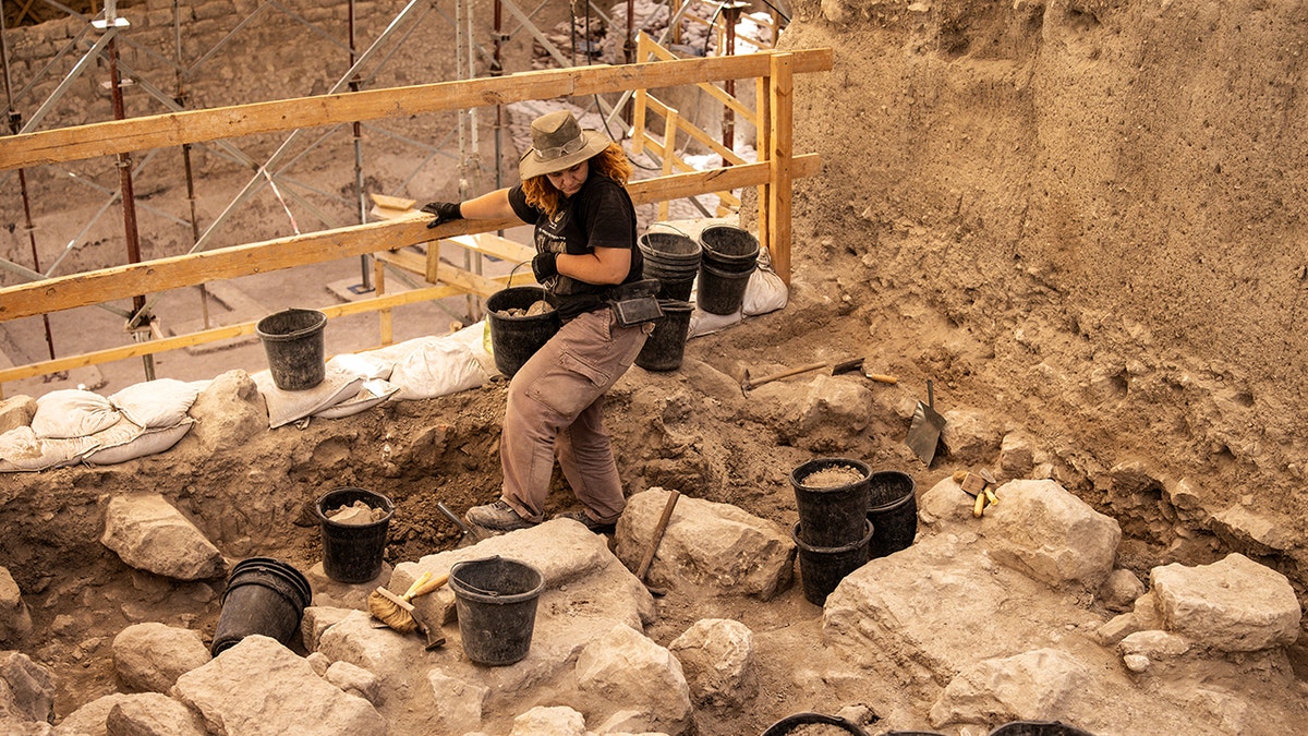 Archaeologists walk among the stones on site
