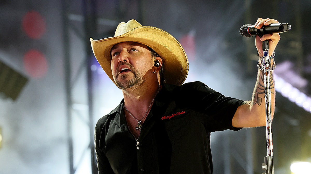 Jason Aldean holds a microphone during CMA Festival 2025