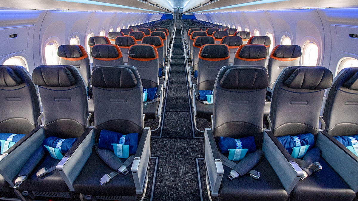 The empty economy section of a JetBlue Airways Corp. inaugural flight from John F. Kennedy (JFK) Airport in New York, U.S, to London Heathrow Airport (LHR) in London, U.K., on Thursday, Aug. 12, 2021. Seen from front of plane looking down aisle with empty three-seat rows on either side.