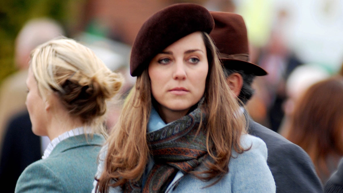 Kate Middleton looking downcast while wearing winter clothes and a dark beret.