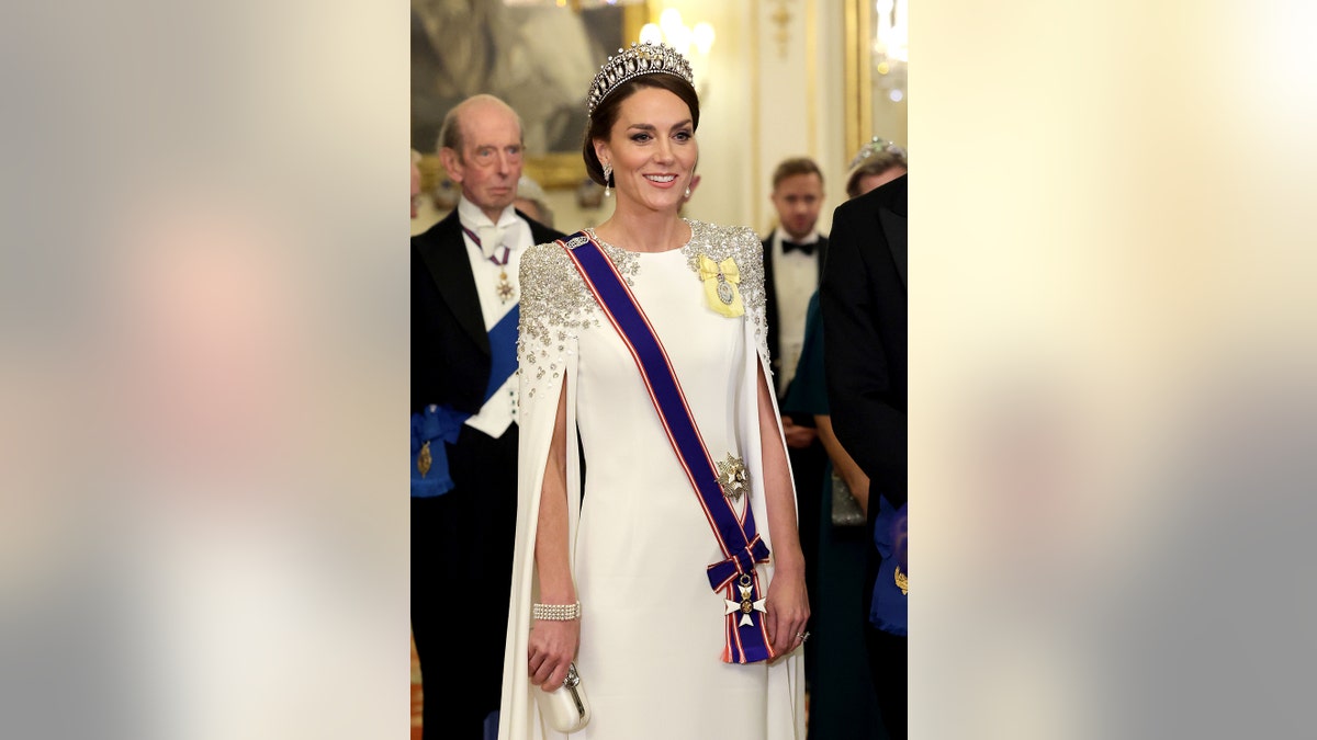 凱特·米德爾頓(Kate Middleton)穿著皇家連衣裙穿著皇冠和藍色翅膀。