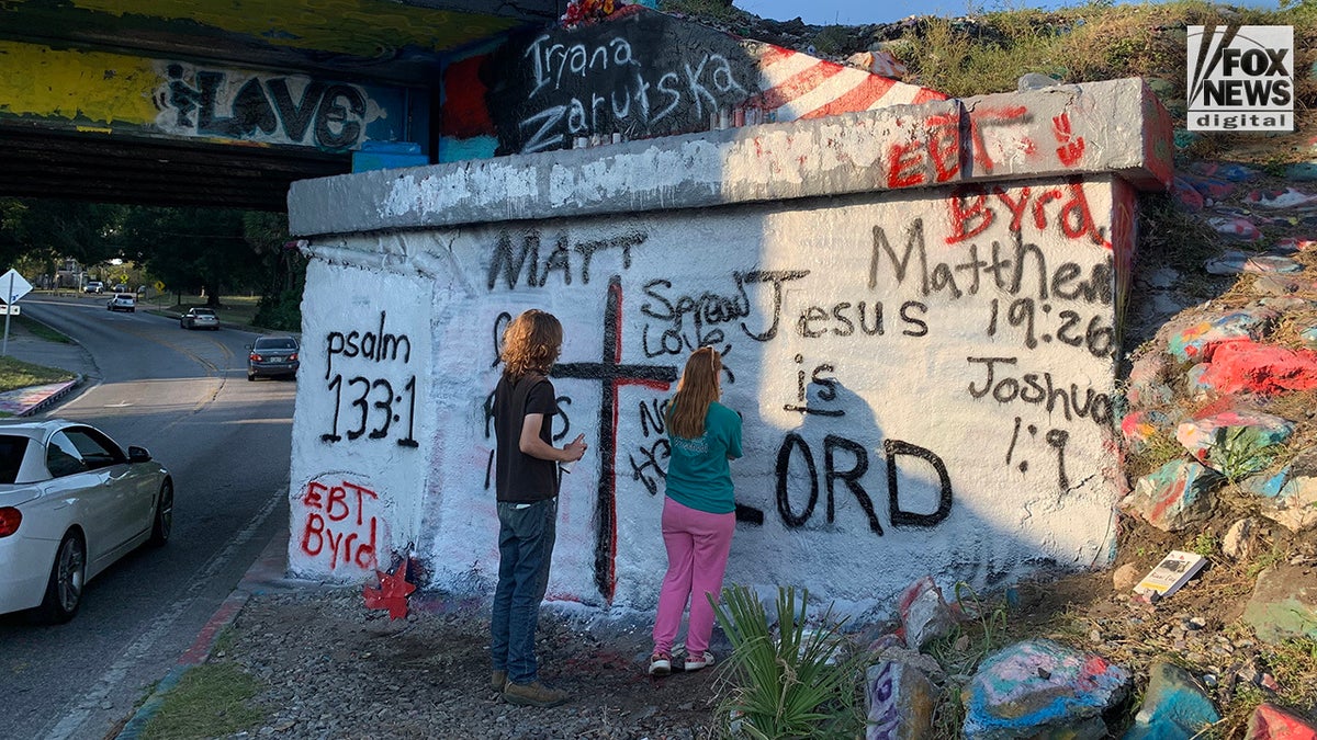 Young people adding Bible verses to the mural