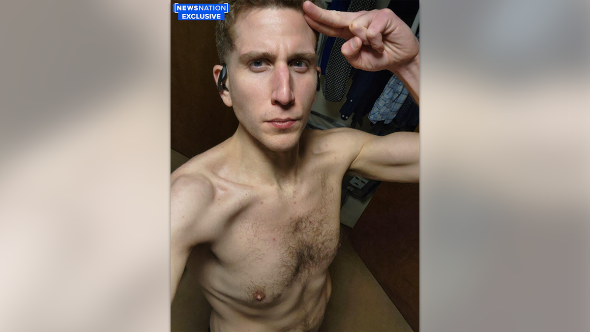 Shirtless Bryan Kohberger wearing wireless headphones, saluting the camera with a cut on his knuckle in a selfie