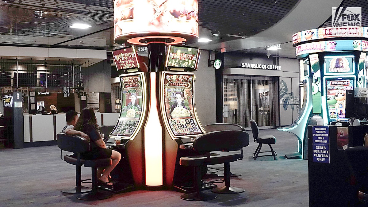 Tourists play slot machines at airport in Las Vegas.