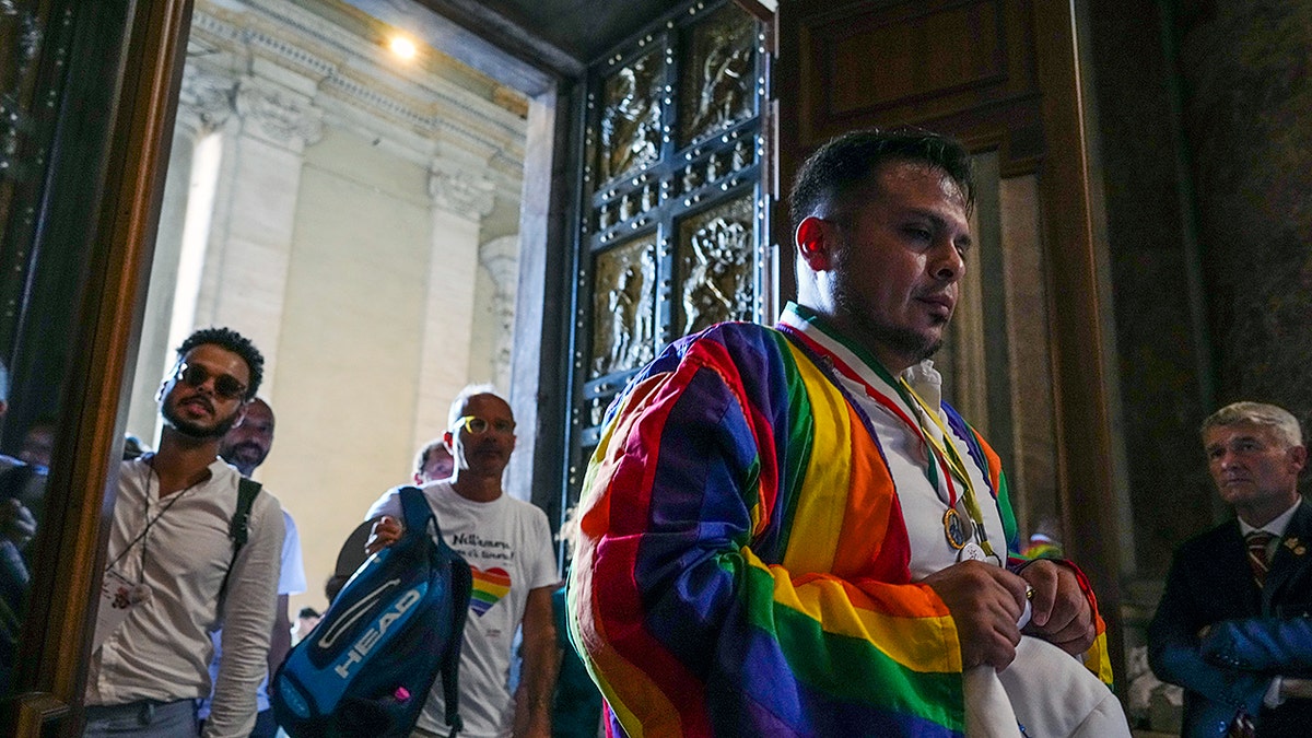 LGBTQ man wearing rainbow attire enters Vatican