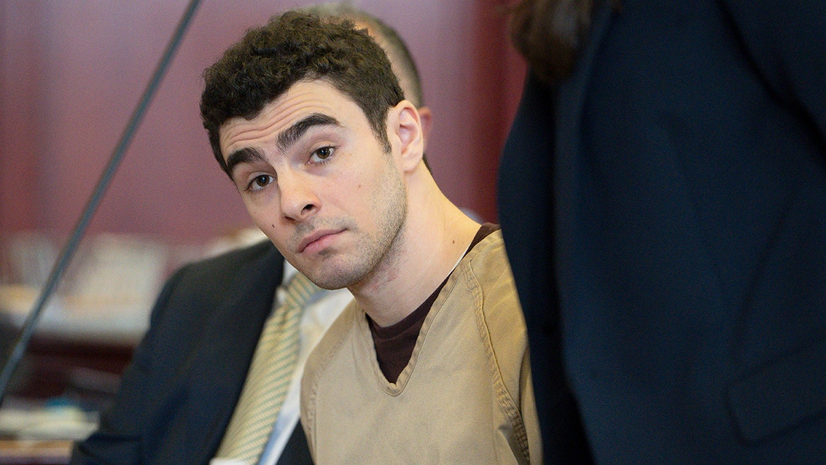 Luigi Mangione seated in court as judge drops terrorism charges.