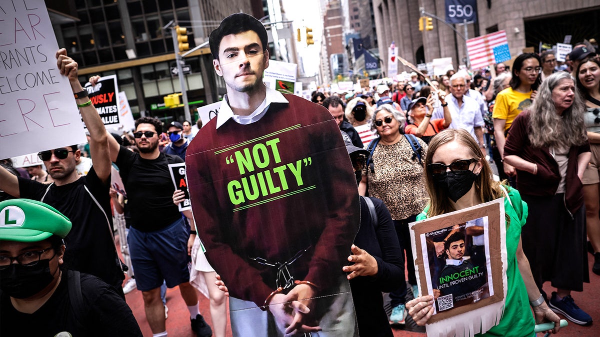 Supporters march with a cardboard cutout of Luigi Mangione