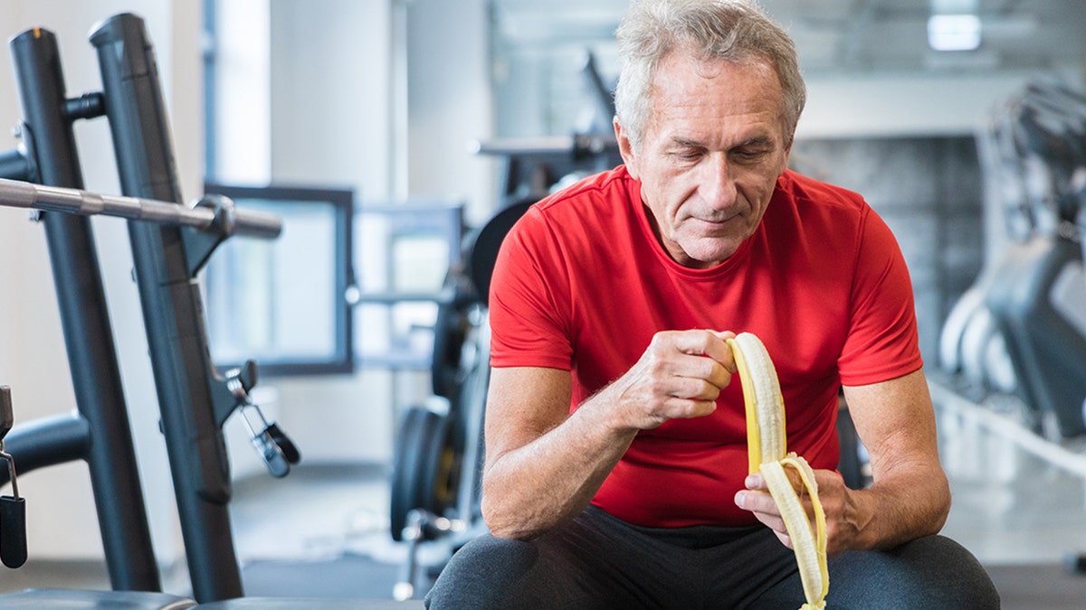 Senior man eating banana