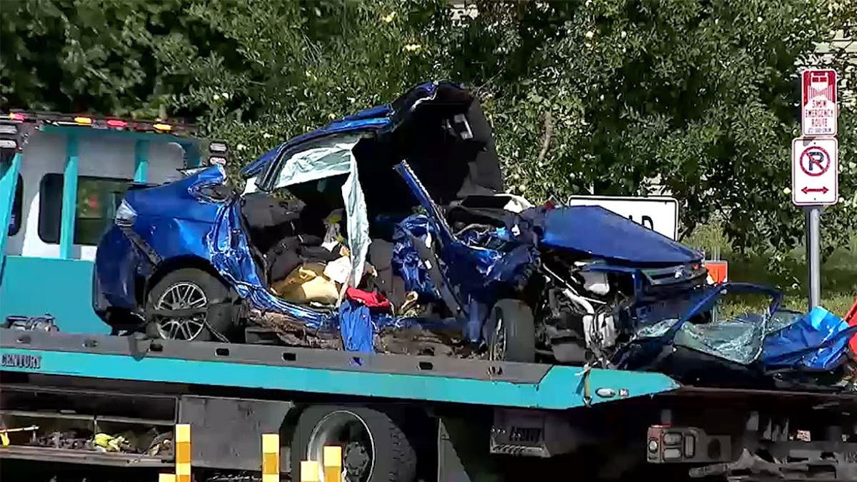 A blue Ford Focus is loaded onto a tow truck after a fleeing suspect ran a red light at Penn Avenue and Olson Memorial Boulevard on Sept. 4, 2025, authorities say.