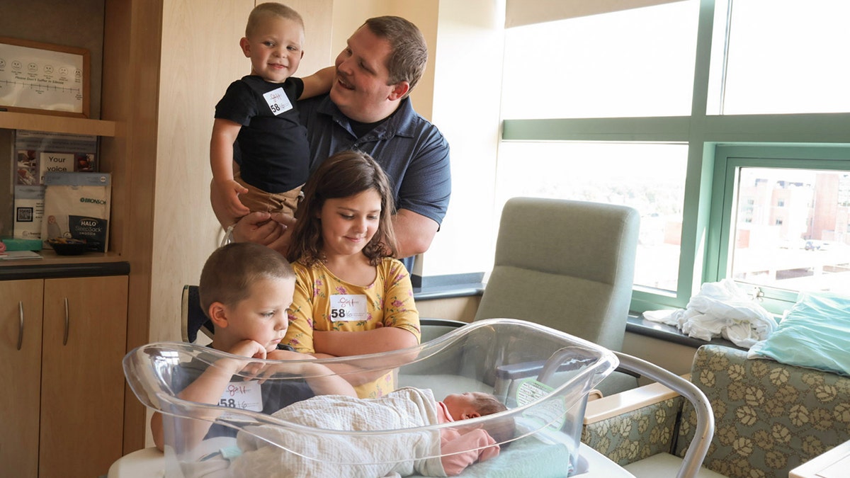 Rotunda siblings and dad posing with newborn Matilda in the hospital after she was delivered in the parking lot of a McDonald's in Michigan.