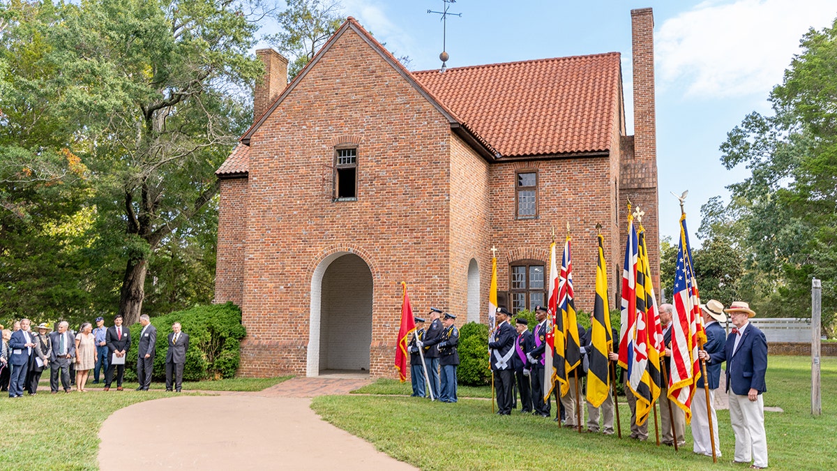 People standing outside brick chapel during ceremony