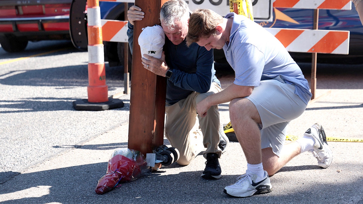 People pray outside the location of a shooting at a church in Michigan