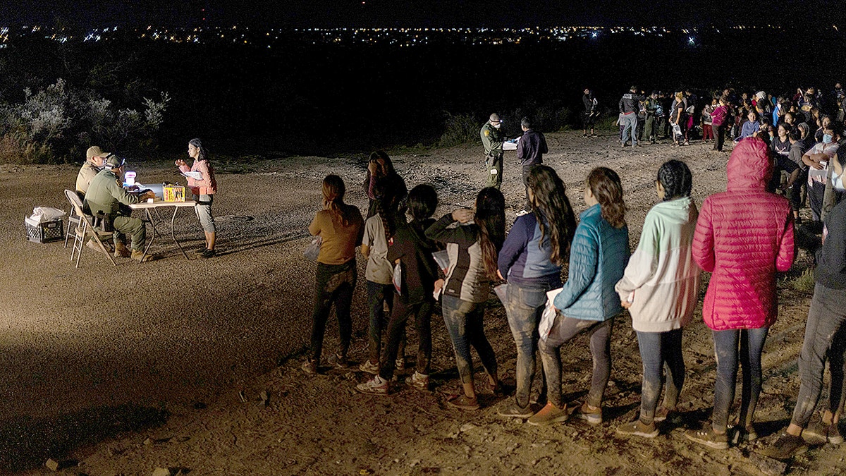 Migrants lined up in a field
