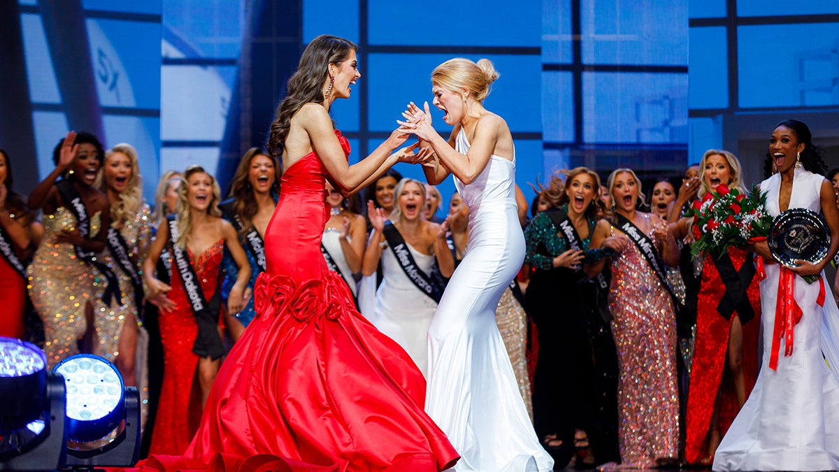 Miss America expressing her excitement with the runner-up on stage.