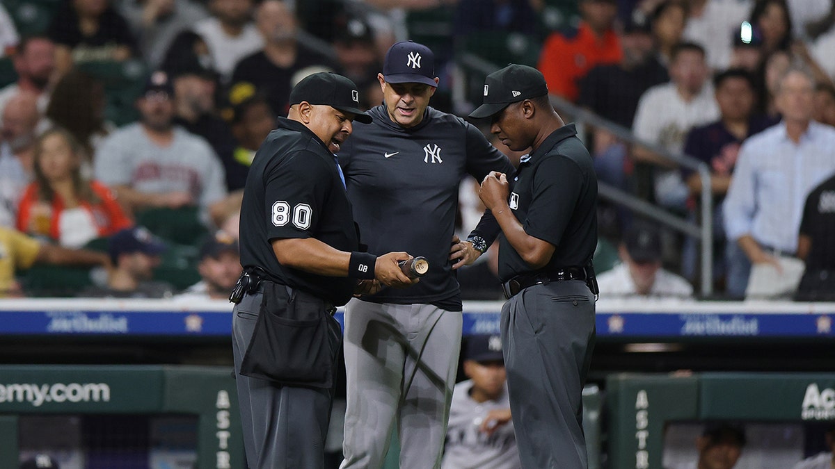 Umpires talk with New York Yankees manager Aaron Boone