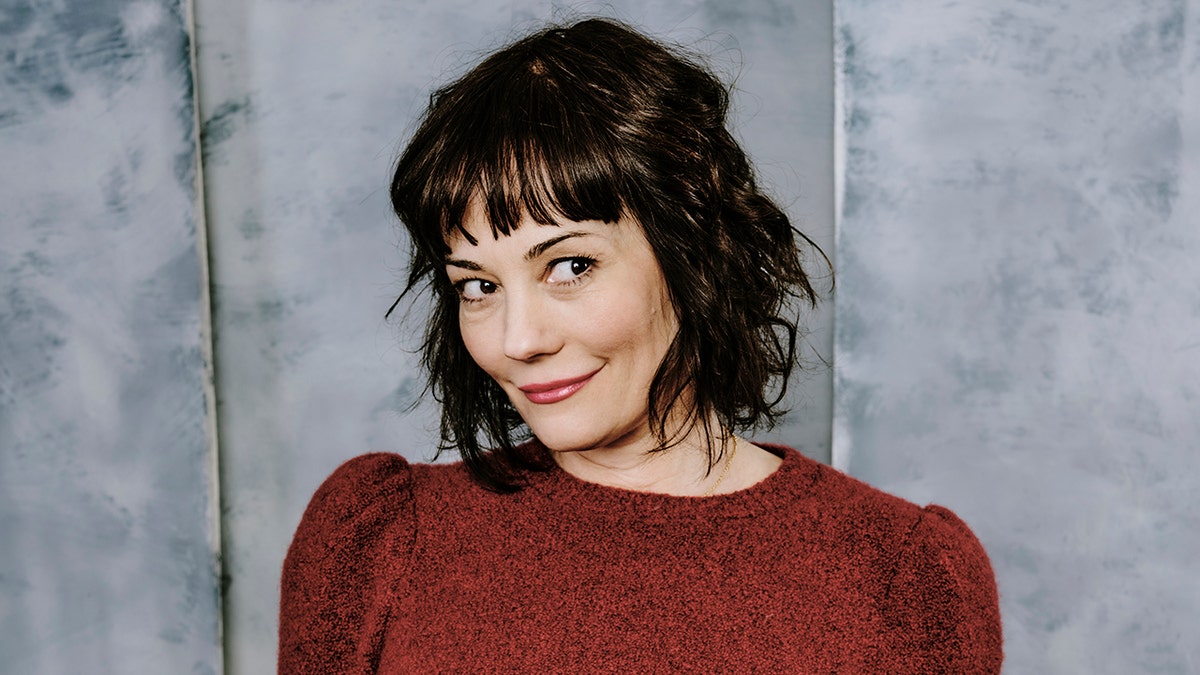 Natasha Gregson Wagner in a read sweater posing for a portrait.