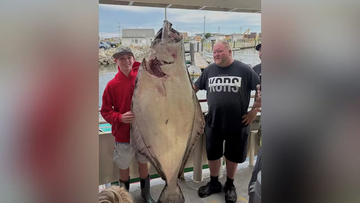 Jackson Denio caught fish on a deep-sea fishing trip in Hampton, New Hampshire on Tuesday, September 2, 2025, standing next to the 177-pound halibut and crew.