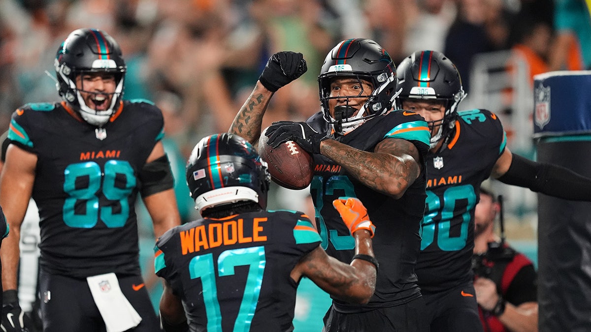 Dolphins players celebrate with Darren Waller