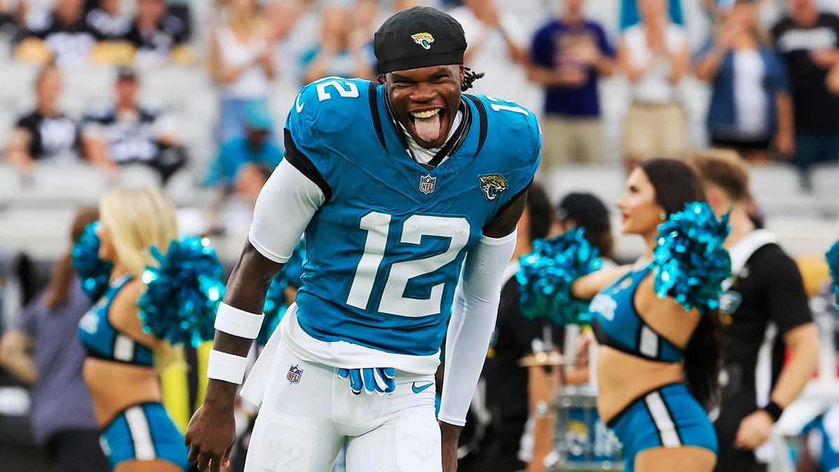 Travis Hunter runs onto the field