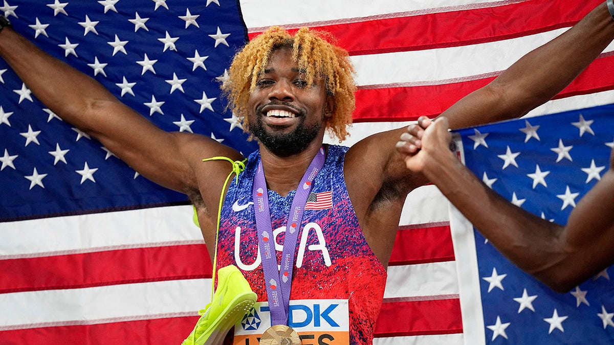 Noah Lyles poses with flag