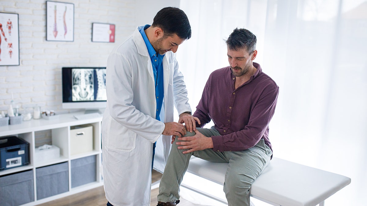 Orthopedic doctor examines patient's knees
