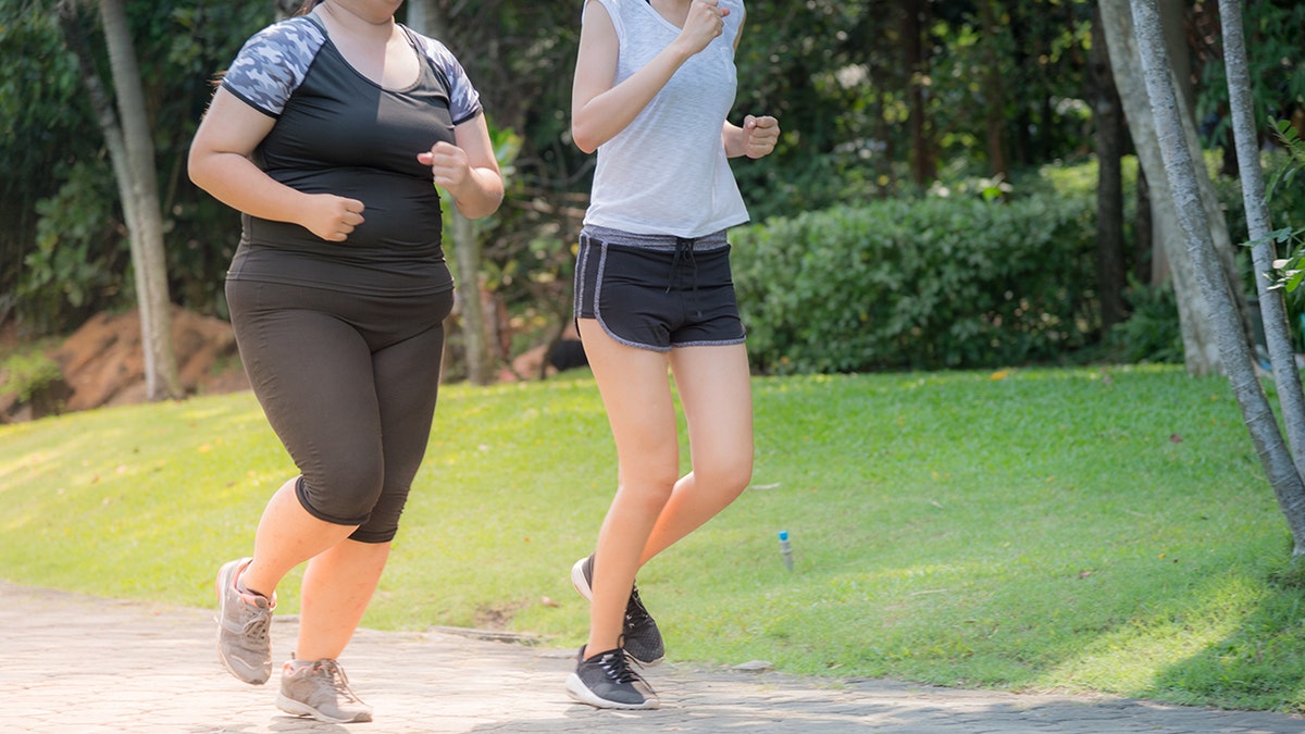 A heavy and thin woman, seen only from her neck, jogged together on an outdoor path.