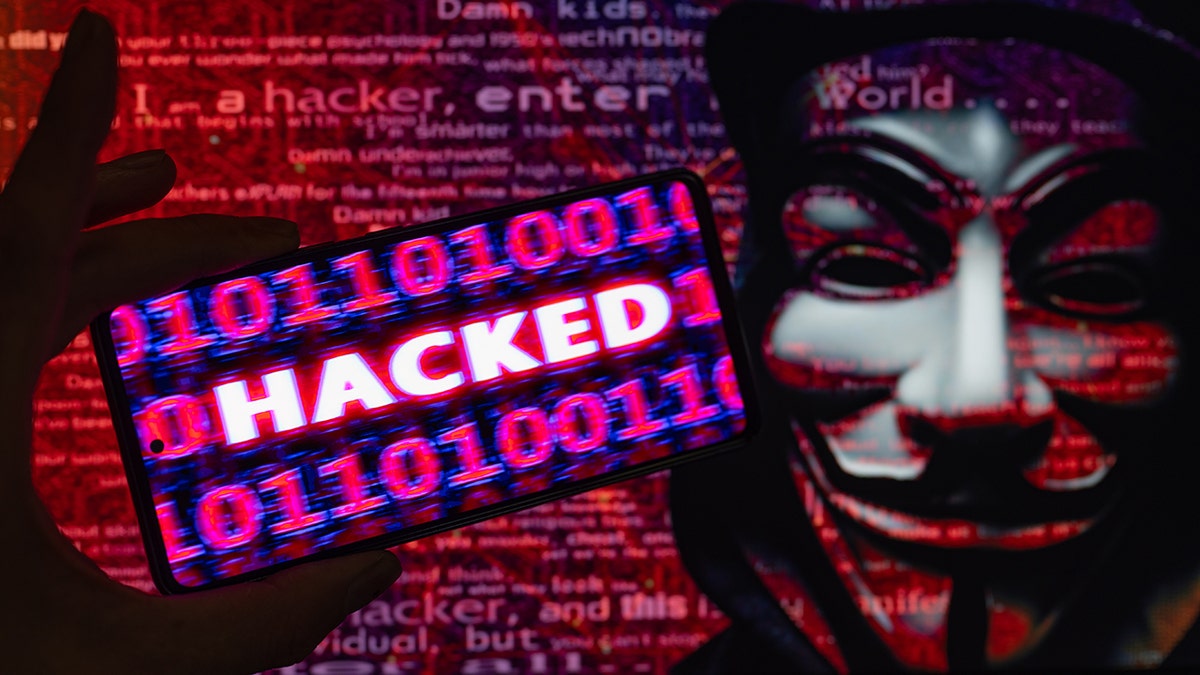 Um homem é um gráfico de hackers usando uma máscara Fawkes.