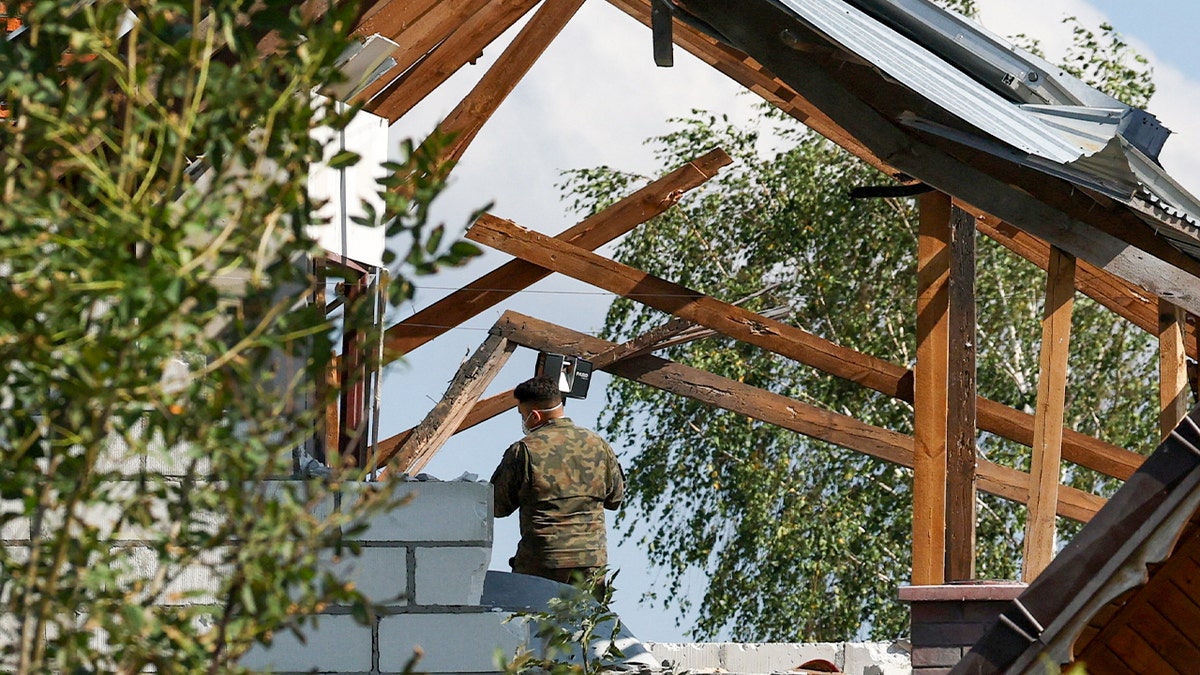 Polski żołnierz sprawdza uszkodzony dom