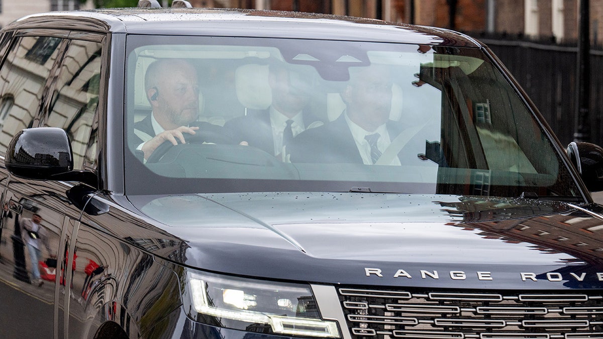 Prince Harry inside a car being driven.