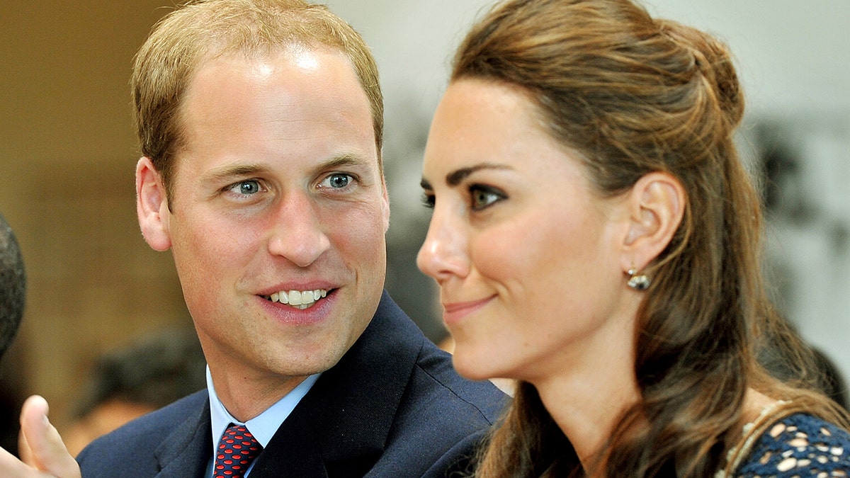Prince William staring and smiling at Kate Middleton as she makes a funny face.