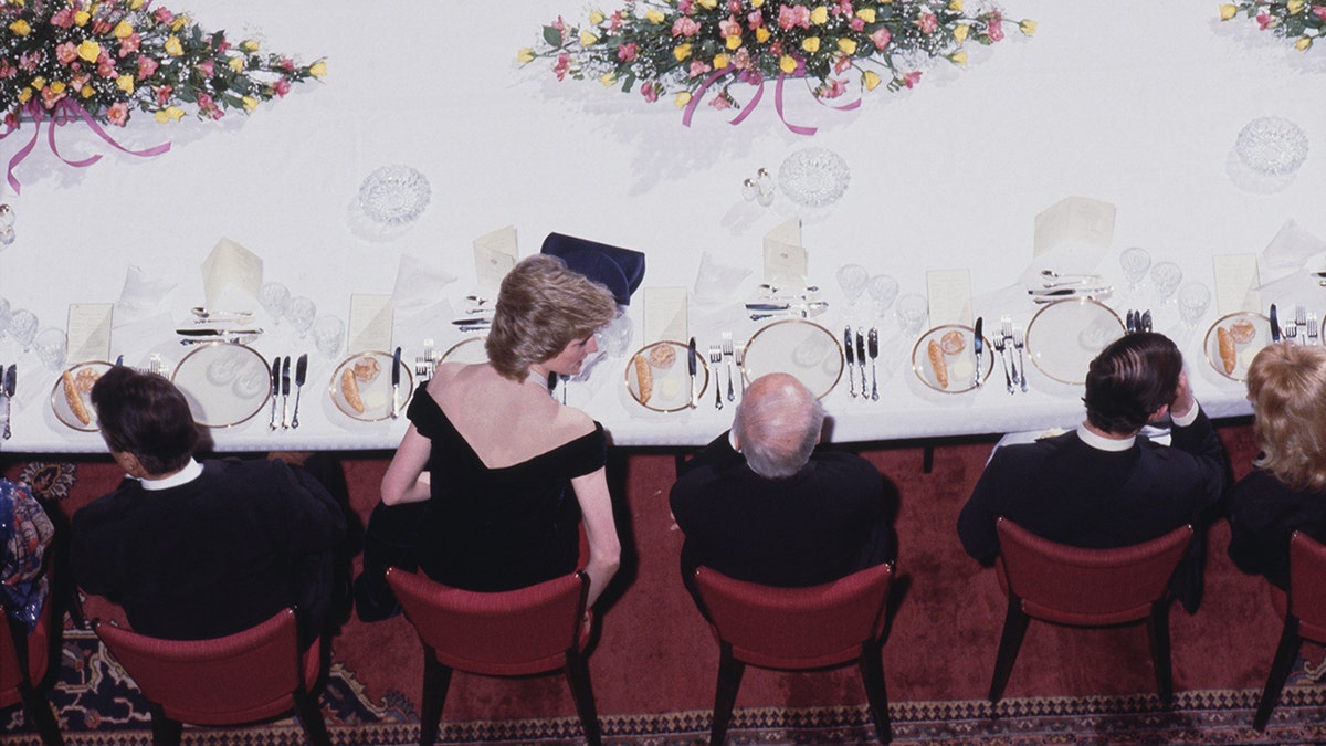 Princess Diana speaking to a male guest during a state dinner.