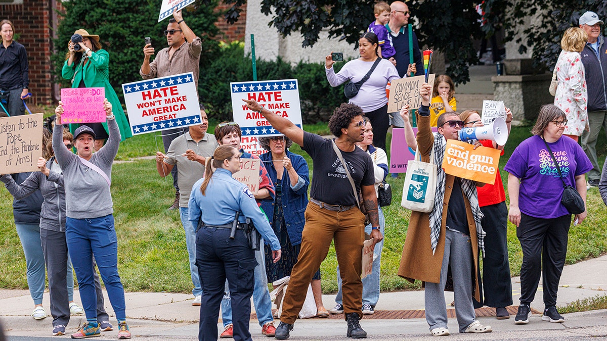 Protesters line the street to voice their opposition to gun violence as Vice President JD Vance departs Minneapolis, Wednesday, Sept. 3, 2025.