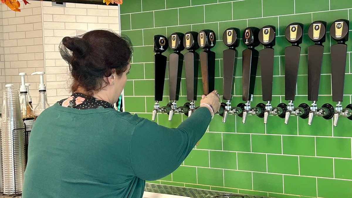 A Publix bartender pours a beer from a tap.