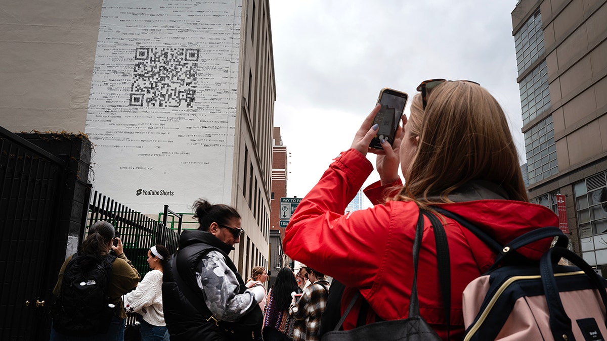 A woman scanning a QR code on a building