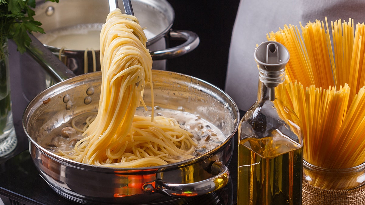 Cook straining spaghetti from hot water