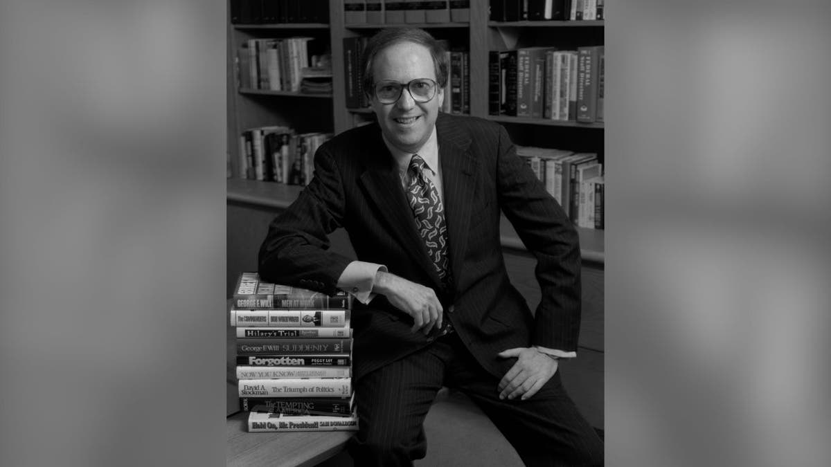 Robert Barnett seated next to a stack of books in his Washington office.