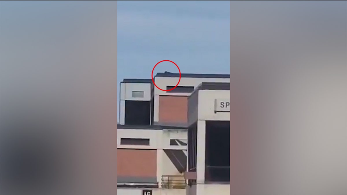 Red circle about what seems to be a person in a black that is placed on the roof at Utah Valley University