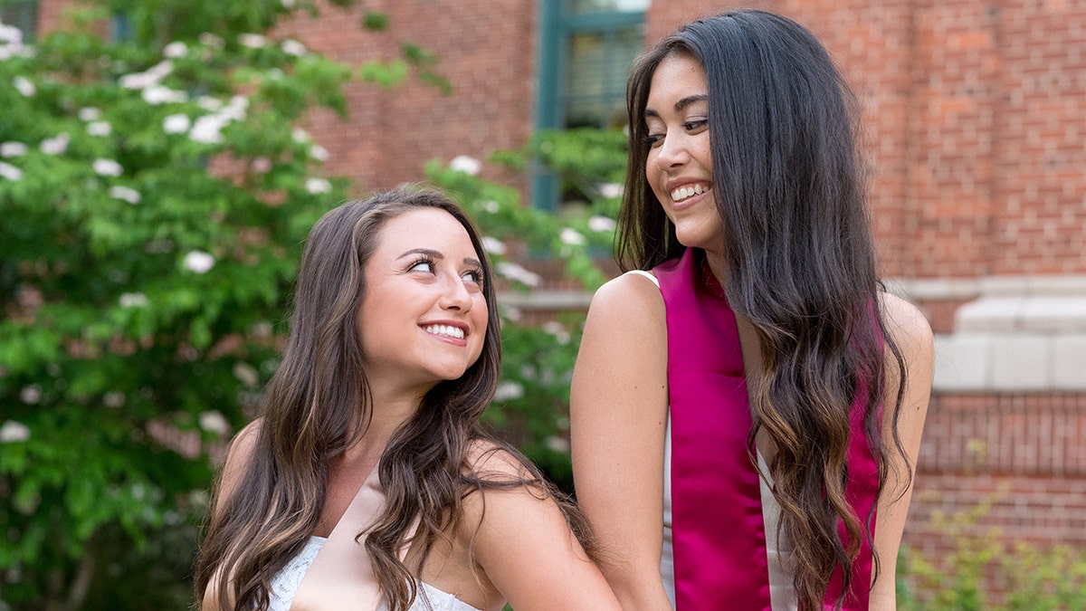 Best friends pose for a photo together on a university campus