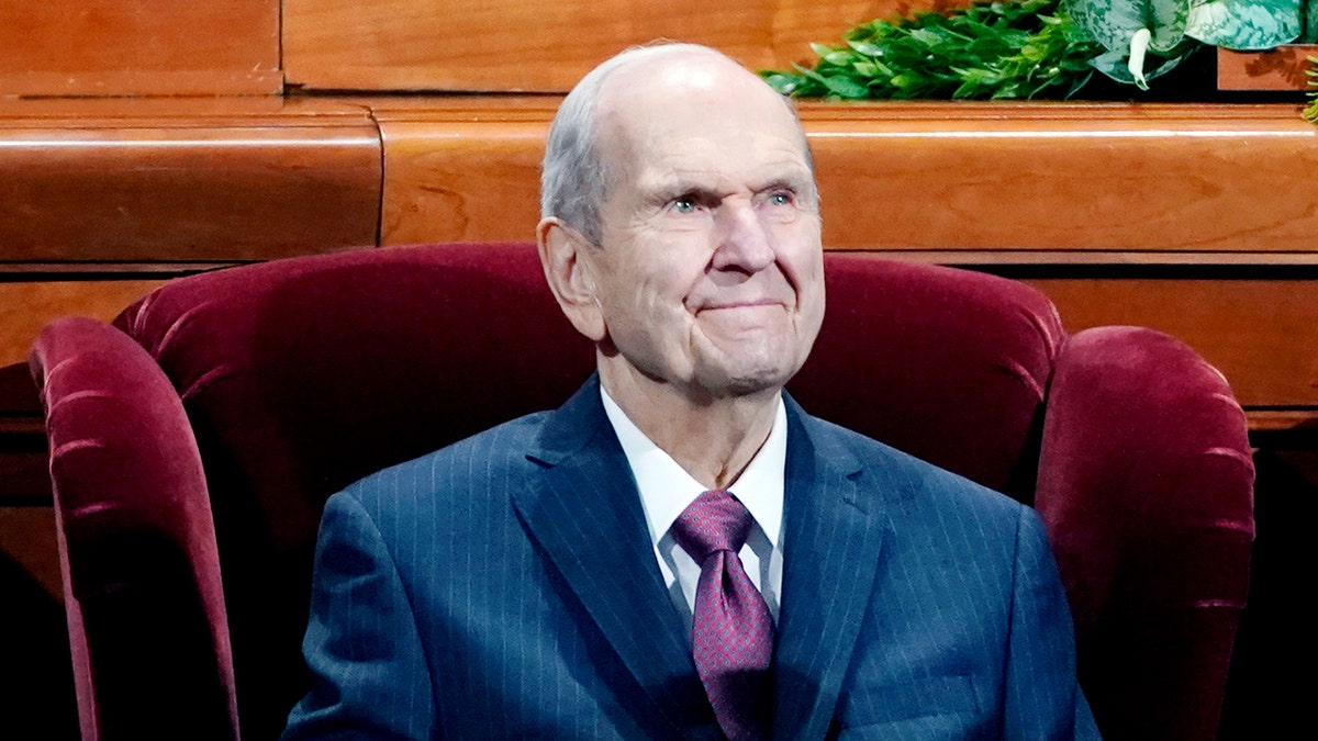 Nelson seated in a chair.