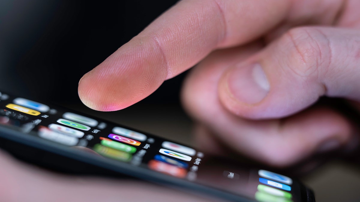 Person selecting an app on an iPhone.