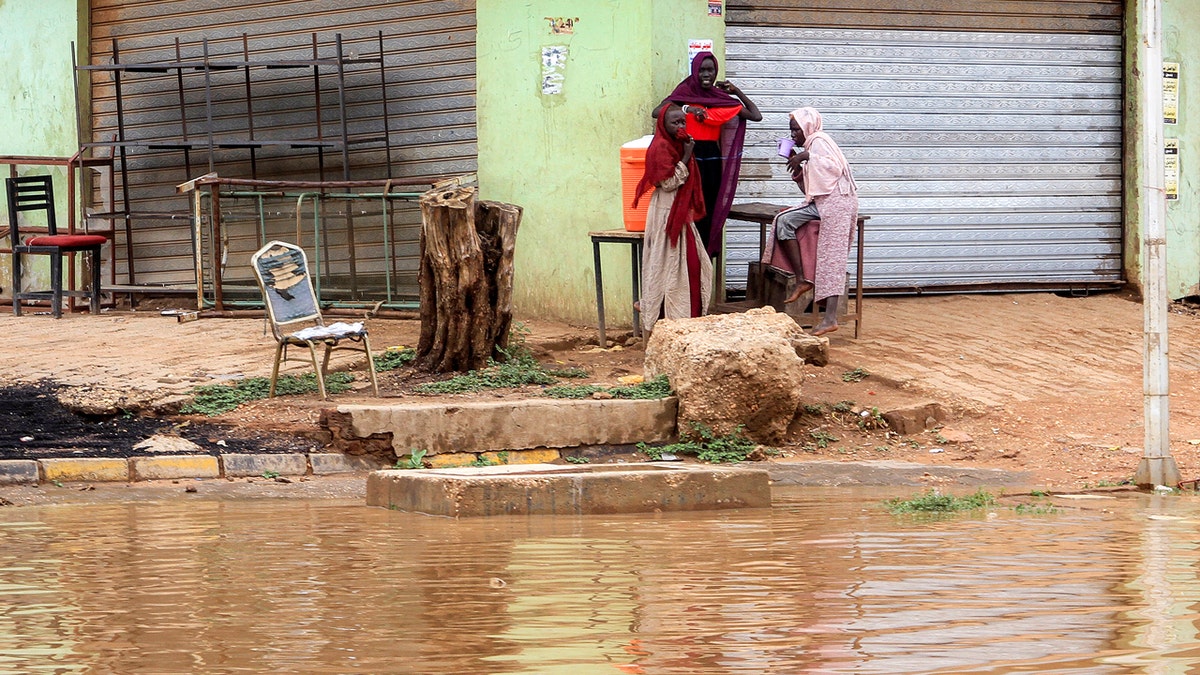 Women gather along the side of the flood flooding
