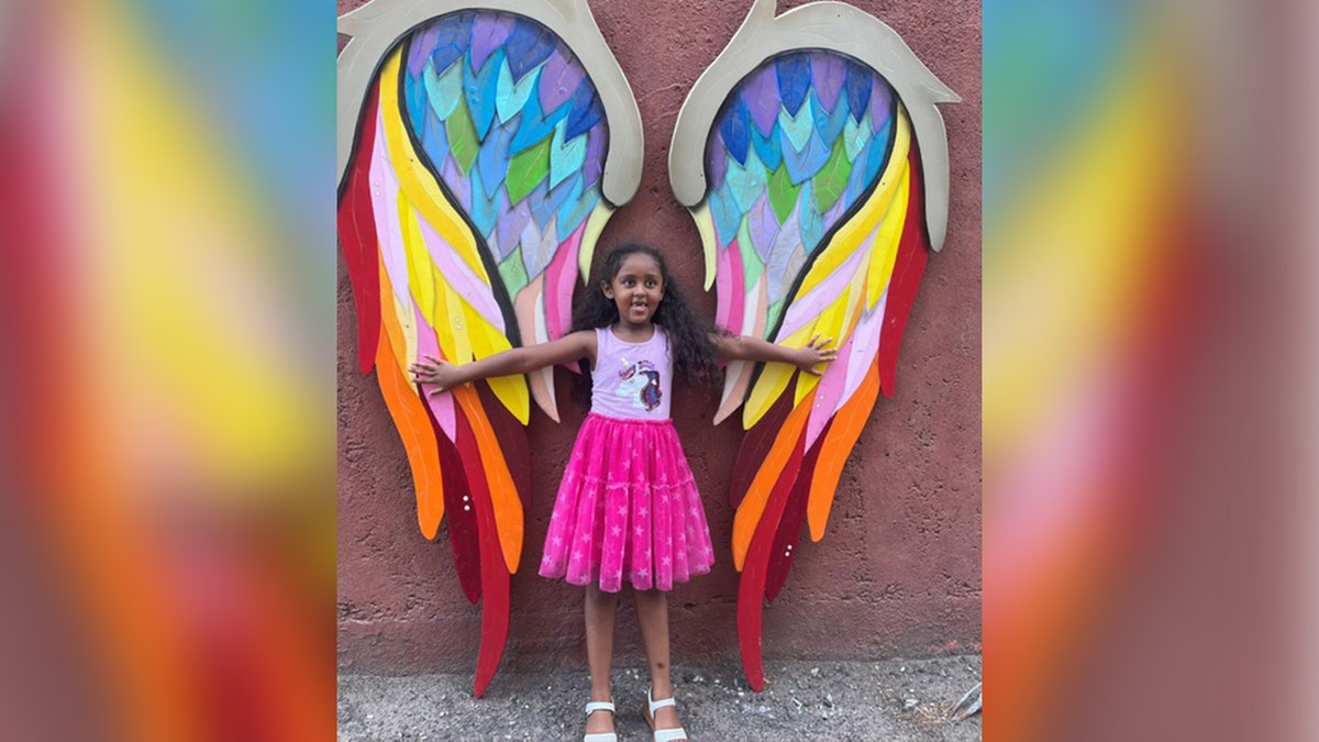 Wongel Estifanos posing in front of colorful art