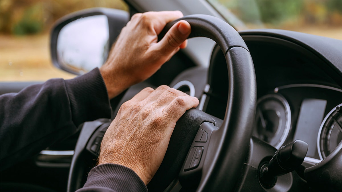 Hands behind wheel